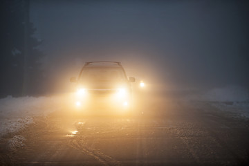 Headlights of car driving in fog