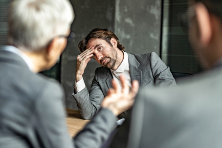 man sitting at table unhappy
