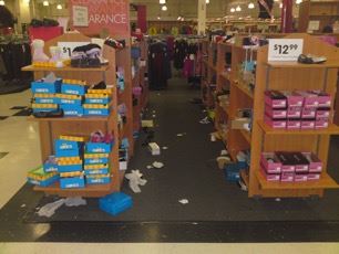 Untidy store shelves with products on the floor